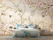 Elegant bedroom interior featuring a pastel Chinoiserie wall mural with delicate cherry blossoms and birds, decorating a bedroom.