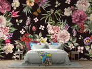 Moody botanical wall art behind bed with layered bedding and bedside flowers.