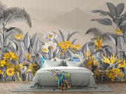 Modern tropical botanical wall mural with grayscale jungle leaves, vibrant yellow flowers, and a misty mountain backdrop in a cozy bedroom setting.
