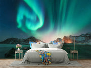 Northern lights wall mural featuring green and blue auroras over snowy mountains and a frozen lake, creating a mesmerizing and tranquil atmosphere.