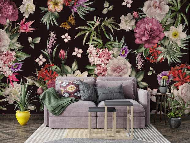 Lush botanical wallpaper in a boho-style living room with colorful pillows and indoor plants.