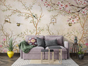 Elegant bedroom interior featuring a pastel Chinoiserie wall mural with delicate cherry blossoms and birds, decorating a living room with sofa.