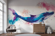 Vibrant galaxy whale wall mural featuring a watercolor-style blue whale swimming through a cosmic, star-filled background in shades of blue, purple, and pink – perfect for kids' rooms and modern decor.