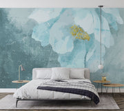 A modern bedroom with a Blue Floral Watercolor Wall Mural, featuring a delicate oversized flower in teal and gold hues. Creating a cosy and elegant space with a soft, artistic ambience.