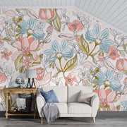 Pastel floral wall mural featuring hand-drawn flowers in pink, blue, and green tones, paired with a white sofa and modern living room decor.