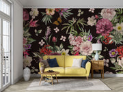 Black floral wall mural with romantic garden design behind a yellow couch in a sunlit living room.