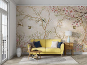 Elegant bedroom interior featuring a pastel Chinoiserie wall mural with delicate cherry blossoms and birds, decorating a living room with yellow sofa.