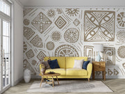 Modern tribal geometric wall mural in gold and white with abstract patterns, styled in contemporary living room with yellow sofa.