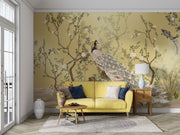 Golden Bloom wall mural with a cream peacock, flowering tree branches, and birds on a golden background in an elegant, Chinoiserie-style interior.