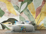 Abstract watercolor leaf wall mural with earthy green, yellow, and terracotta tones in a modern botanical design.