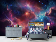 Celestial nebula wall mural featuring vibrant clouds of cosmic gas in blues, purples, and reds with glowing stars, styled in a modern bedroom.