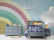 Modern bedroom with retro pastel rainbow wall mural and sky backdrop.