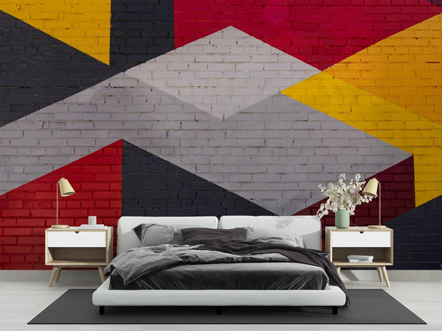 Modern geometric wall mural with an urban brick texture featuring bold abstract shapes in red, yellow, black, and gray. Ideal for industrial-style living rooms, lofts, and offices.
