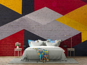 Modern geometric wall mural with an urban brick texture featuring bold abstract shapes in red, yellow, black, and gray. Ideal for industrial-style living rooms, lofts, and offices.
