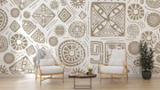 Modern tribal geometric wall mural in gold and white with abstract patterns, styled in a contemporary living room with two chairs.