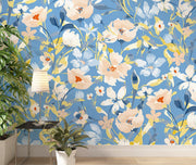 Modern floral wall mural with a bold blue background and beige and yellow flowers in a contemporary living room .