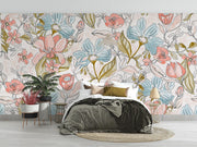 Pastel floral wall mural featuring hand-drawn flowers in pink, blue, and green tones, decorating a modern bedroom.