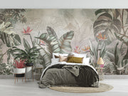 Elegant tropical wall mural with monstera leaves and birds of paradise flowers in sage green and coral, styled in modern bedroom.