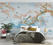 Chinoiserie-style wall mural featuring cherry blossom branches, perched birds, and misty blue mountains, creating a serene and elegant atmosphere.