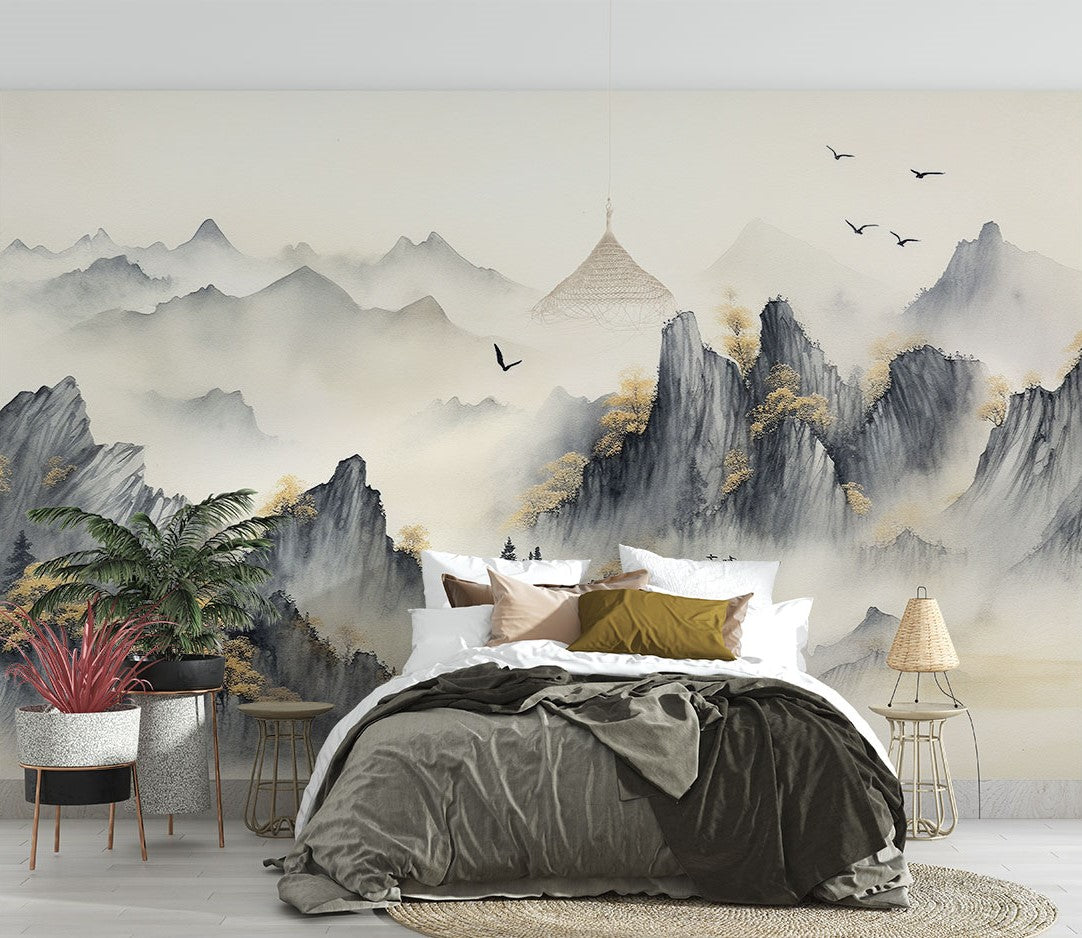 A tranquil bedroom featuring a Tranquil Peaks Wall Mural with misty watercolor mountains and golden foliage. Styled with earthy bedding, woven lighting, wooden furniture, and lush plants, creating a serene and nature-inspired atmosphere.