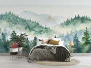 Watercolor forest wall mural with misty mountains and lush green trees, creating a serene and calming nature-inspired ambiance.