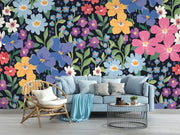 Colorful floral wall mural with hand-painted flowers in shades of blue, pink, yellow, and purple, displayed in a modern living room with a pastel sofa.