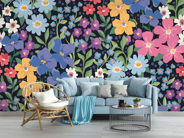 Colorful floral wall mural with hand-painted flowers in shades of blue, pink, yellow, and purple, displayed in a modern living room with a pastel sofa.
