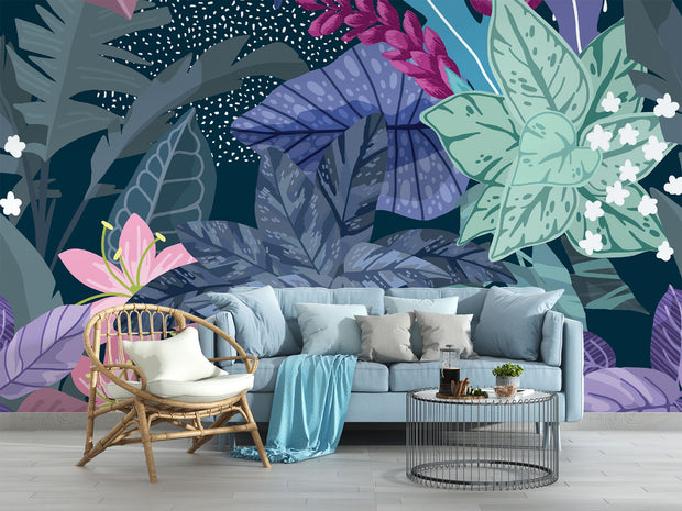 Illustrated tropical botanical wall mural with large jungle leaves, pink lilies, white flowers, and deep blue background, styled in a modern living room.