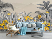 Modern tropical botanical wall mural with grayscale jungle leaves, vibrant yellow flowers, and a misty mountain backdrop in a cozy bedroom setting.