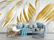 Modern abstract wall mural with golden and beige feather leaf patterns decorating a living room with blue sofa.