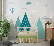 Modern geometric mountain wall mural in teal and grey with hot air balloons and clouds, styled in a contemporary nursery.
