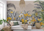 Modern tropical botanical wall mural with grayscale jungle leaves, vibrant yellow flowers, and a misty mountain backdrop in a cozy bedroom setting.