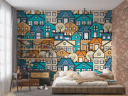 Colorful geometric house wall mural featuring vibrant blue, orange, and beige houses with minimalist trees, creating a modern and lively room atmosphere.