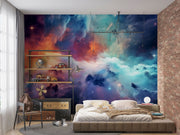 Celestial Dreams galaxy wall mural with colorful nebula clouds in orange, blue, and purple tones, styled in a modern bedroom.
