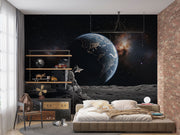 Wall mural of an astronaut sitting on the moon, gazing back at the Earth.