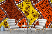 Bold tropical wall mural with vibrant orange, yellow, and brown leaf patterns, accented with white dots, perfect for boho and eclectic interior decor.