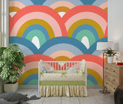 Colorful retro rainbow mural in nursery with white crib and toys.