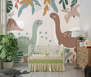 Kids’ wall mural with cartoon dinosaurs, volcano, pterodactyl, and tropical leaves in soft earth tones; styled in a cozy children’s nursery.