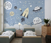 Space-themed wall mural with rocket, UFOs, planets, and constellations on a blue sky background—ideal for kids' room décor.