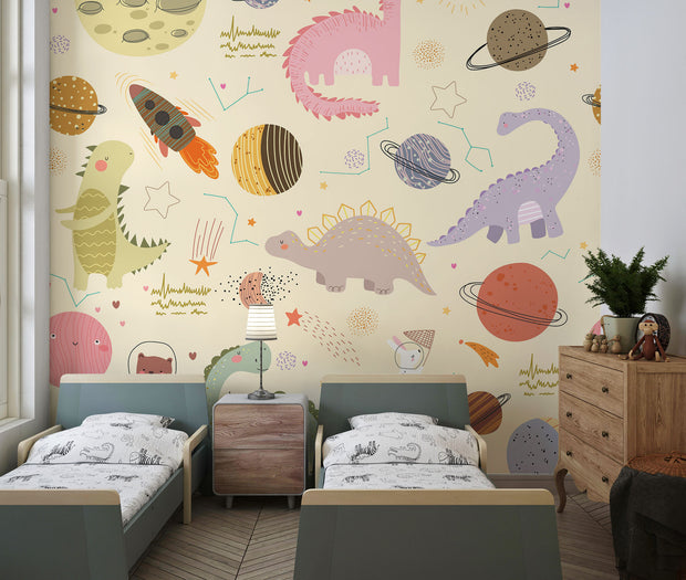 Children's room with Dino Galaxy Wall Mural featuring whimsical dinosaurs, rockets, planets, and stars in pastel colors, creating a magical space-themed decor.