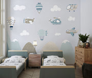 Aviation-themed wall mural for kids featuring airplanes, helicopters, hot air balloons, and mountains in soft pastel colors, perfect for a nursery or playroom.