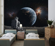 Wall mural of an astronaut sitting on the moon, gazing back at the Earth.