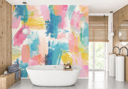 Colorful abstract wall mural with brushstroke patterns in vibrant pink, blue, yellow, and coral shades, installed in a modern bathroom.