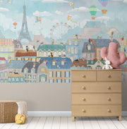 Paris-themed kids’ wall mural with the Eiffel Tower, hot air balloons, colorful rooftops, and kites in soft pastel colors, perfect for a nursery or playroom.
