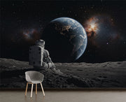 Wall mural of an astronaut sitting on the moon, gazing back at the Earth.