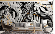 Black and white tropical leaf wall mural with gold accents, featuring monstera and palm leaves in a modern botanical design.