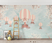 Whimsical kids’ wall mural with baby animals in hot air balloons, cherry blossoms, and a pastel sky—perfect for nurseries and playrooms.