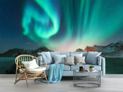 Northern lights wall mural featuring green and blue auroras over snowy mountains and a frozen lake, creating a mesmerizing and tranquil atmosphere.