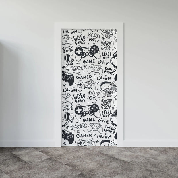 Black-and-white gaming-themed door mural featuring video game controllers, gamer doodles, and phrases like "Level Up!" and "Just Play!"