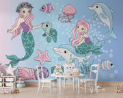 Whimsical underwater-themed mural with pastel mermaids, dolphins, turtles, jellyfish, and fish set against a blue bubble-filled background in a cozy kids' room.